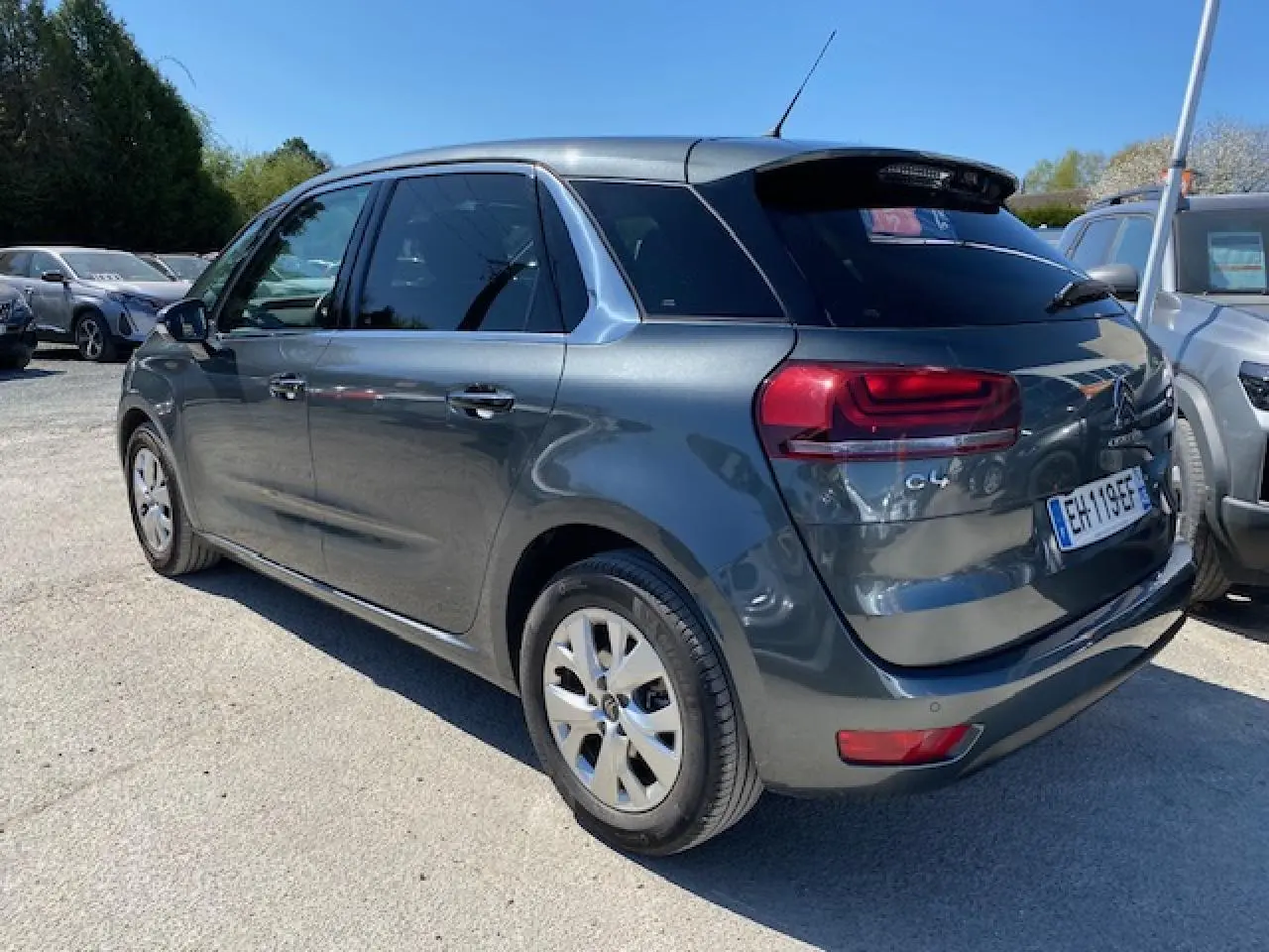 Citroën C4 Picasso gris shark vue 3/4 arrière droit, avec feux LED et jantes alliage 16 pouces visibles.