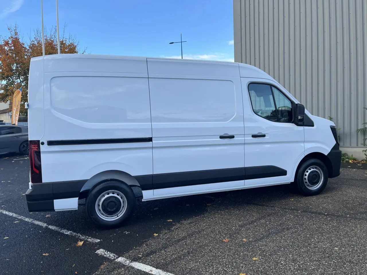 Renault Master blanc vu de profil côté gauche, fourgon tôlé avec jantes acier et protections noires.