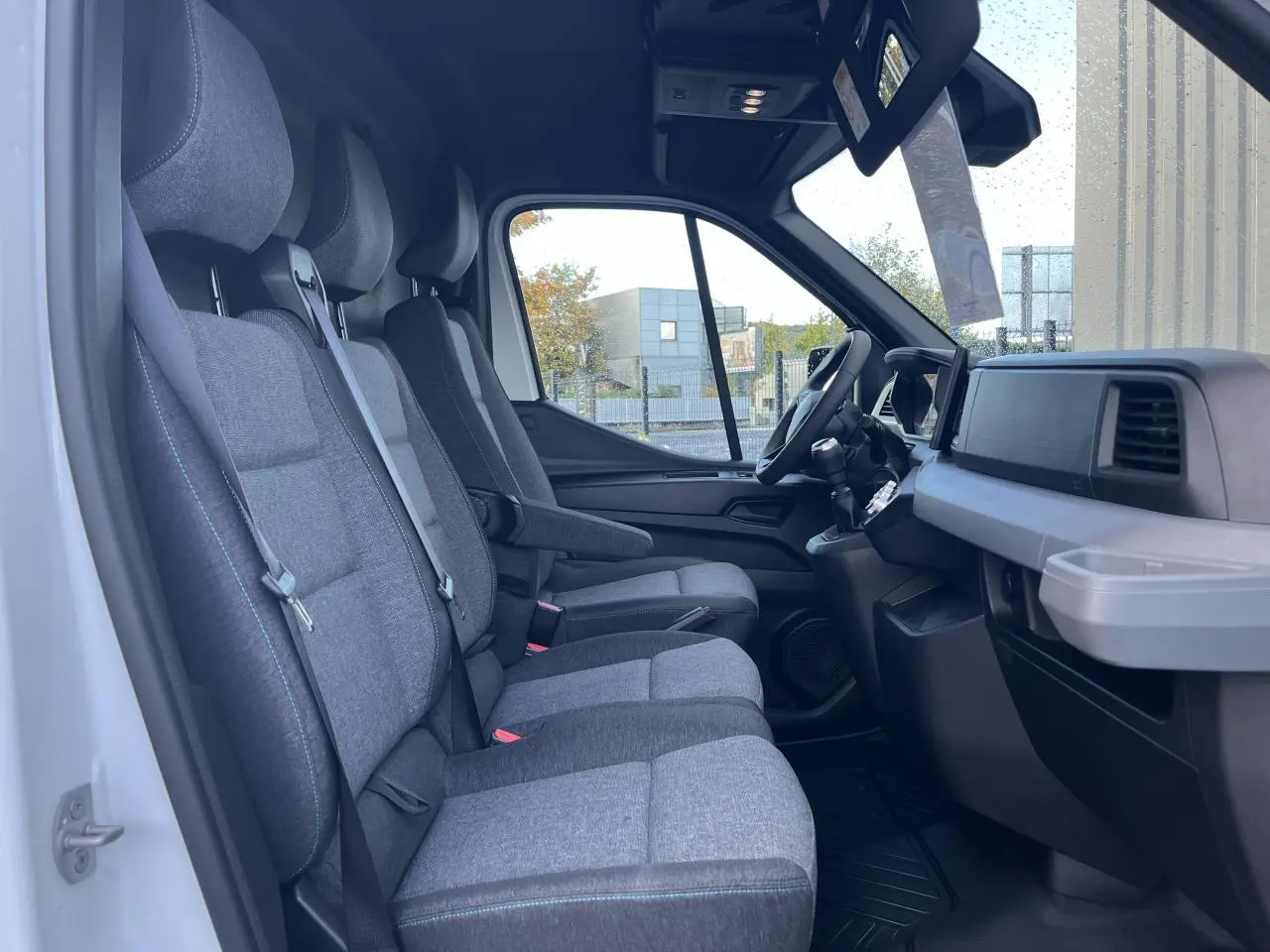 Intérieur du Renault Master blanc vu côté gauche, montrant les sièges tissu gris chiné et tableau de bord noir.