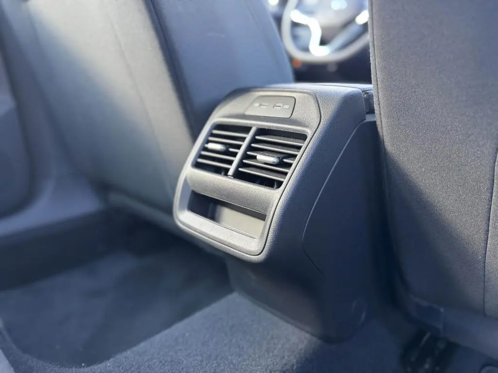 Vue rapprochée de la console arrière noire avec bouches d’aération et ports USB dans une Volkswagen Passat SW 2024.