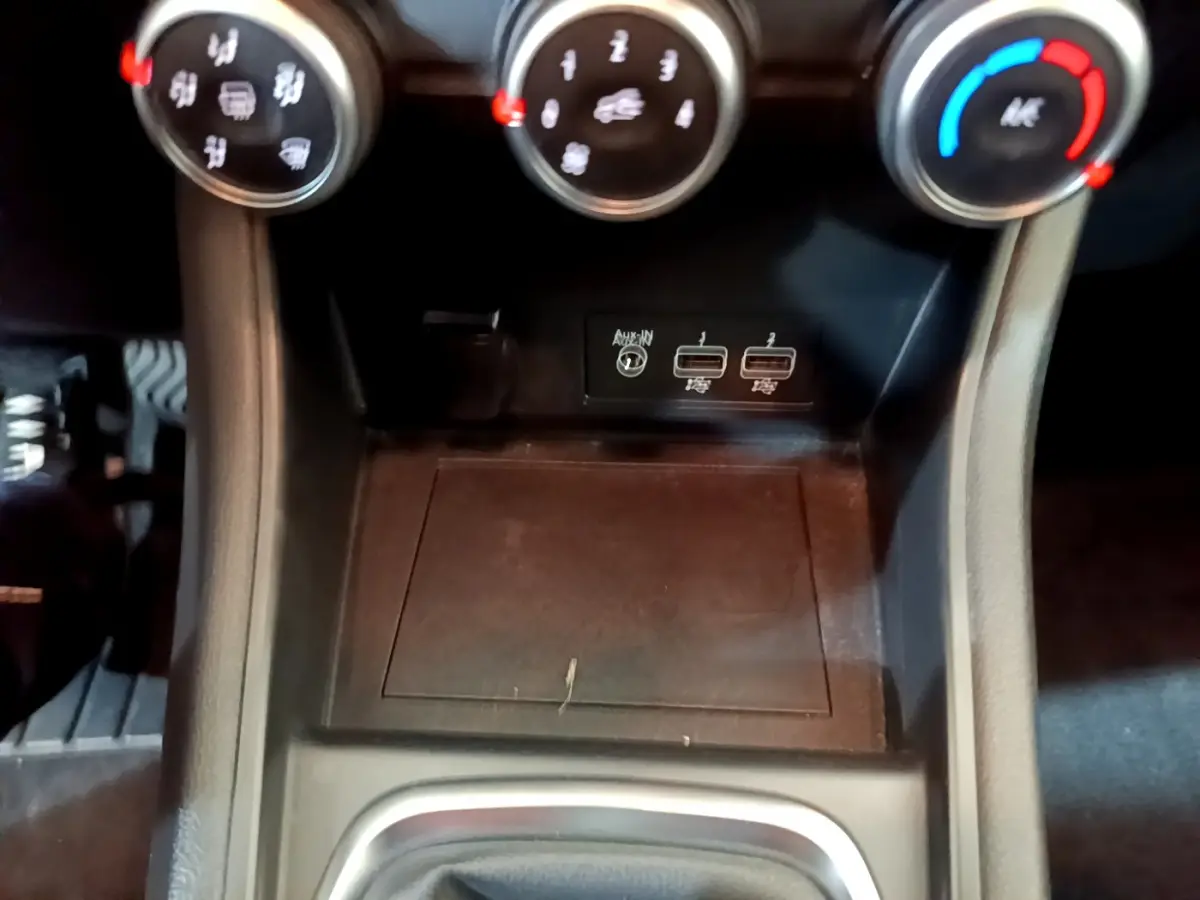 Gros plan sur la console centrale du Renault Captur Business TCe 90 2021, montrant les commandes de climatisation et ports USB.