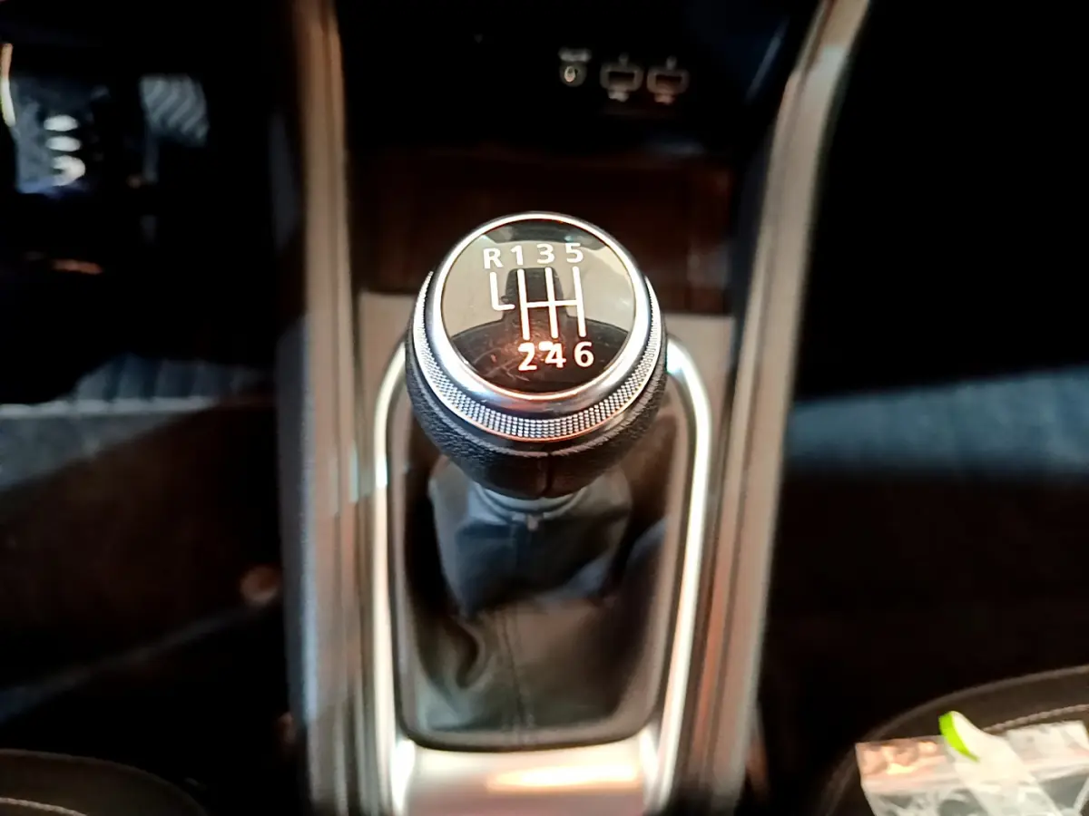 Le levier de vitesses manuel noir du Renault Captur Business TCe 90 de 2021 vu en gros plan depuis l'intérieur central.
