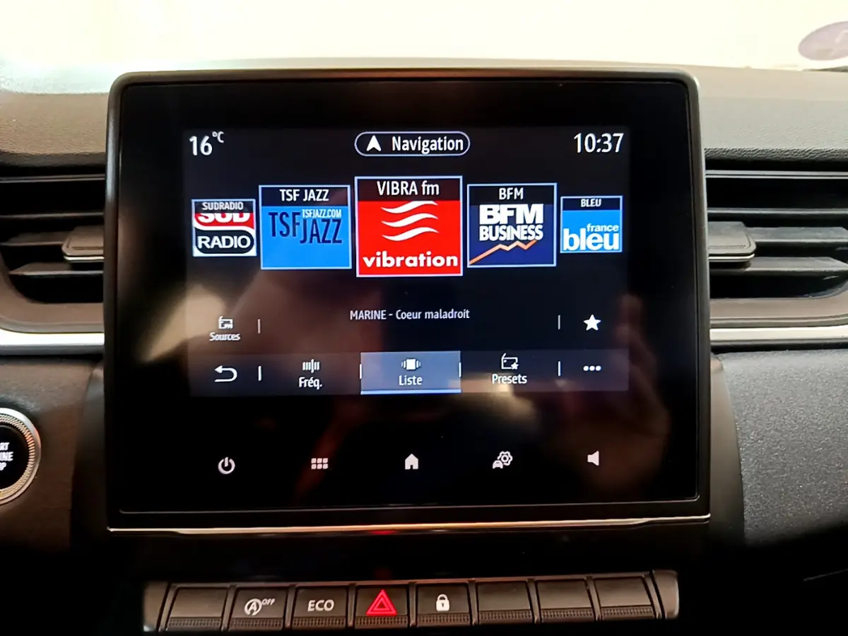 Écran tactile central du tableau de bord du Renault Captur Business noir, affichant les stations radio et la navigation.