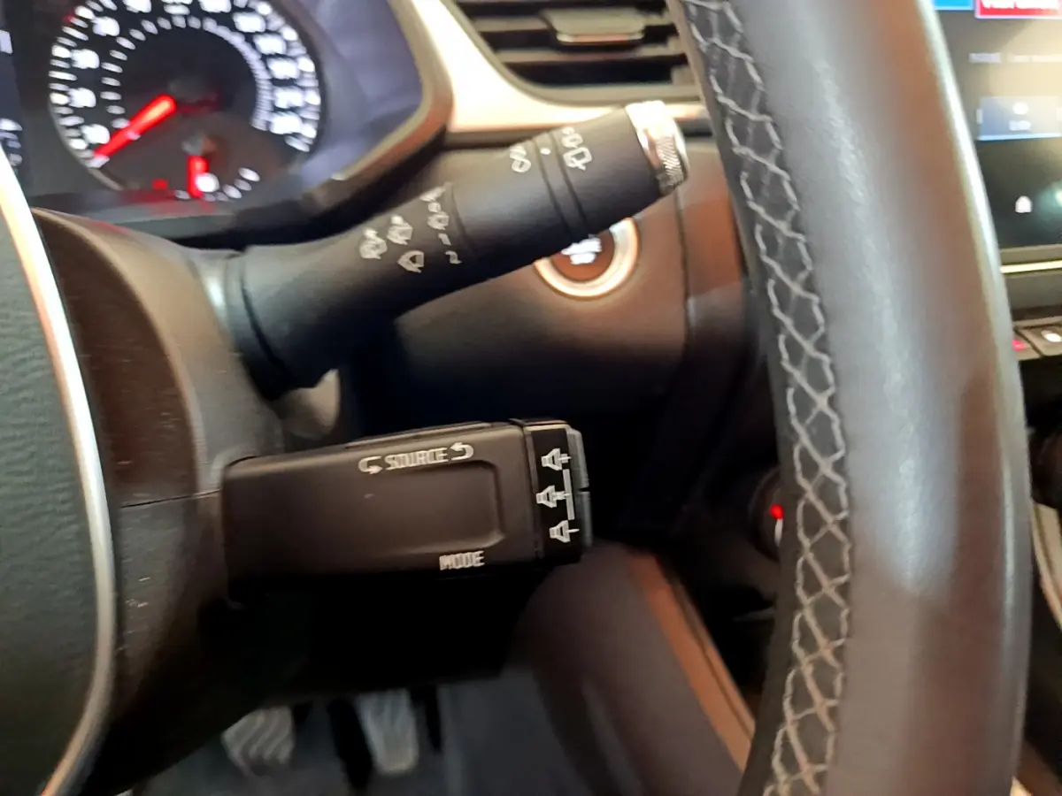 Gros plan sur le commodo gauche et volant noir du Renault Captur Business TCe 90 2021, avec tableau de bord partiellement visible.