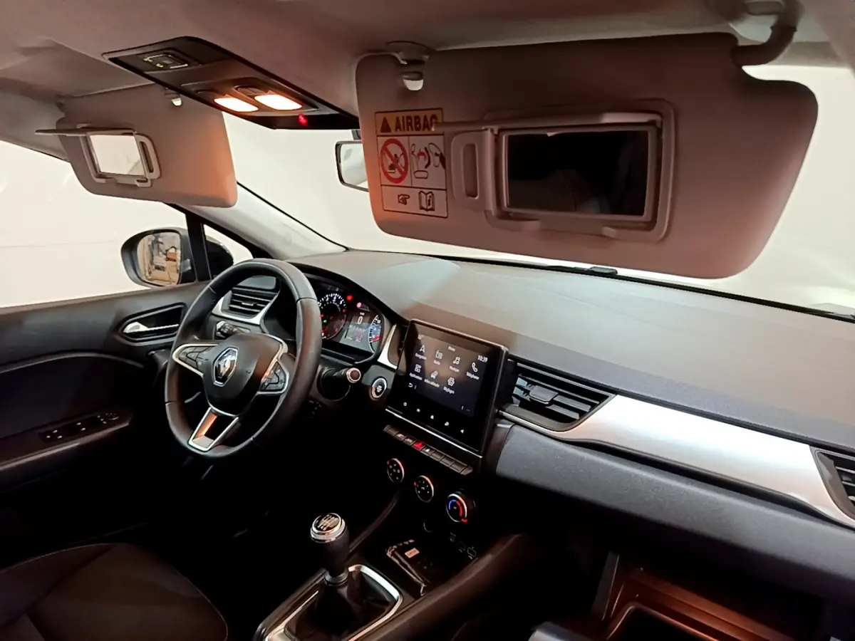 Intérieur du Renault Captur Business TCe 90 2021 vu côté conducteur, tableau de bord avec écran tactile et volant noir.