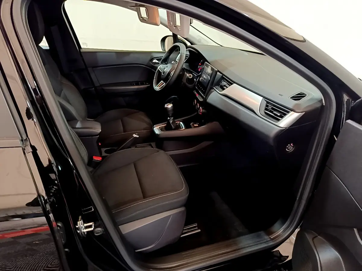 Intérieur noir de la Renault Captur Business TCe 90 2021 vu côté conducteur, avec tableau de bord et écran tactile central.