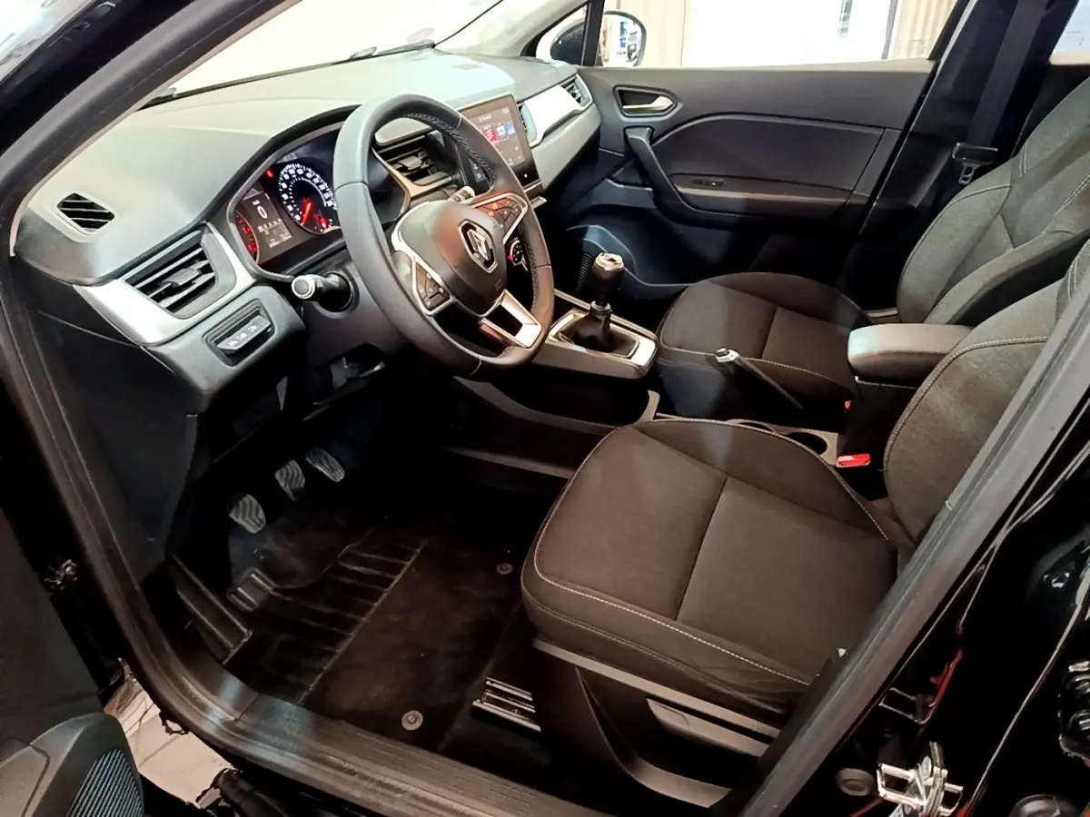 Intérieur avant droit du Renault Captur Business TCe 90 2021 noir, volant multifonctions et boîte manuelle visible.