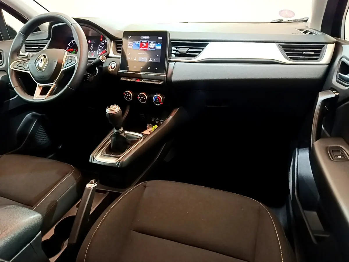 Vue intérieure côté conducteur du tableau de bord noir du Renault Captur Business TCe 90 avec écran tactile et boîte manuelle.