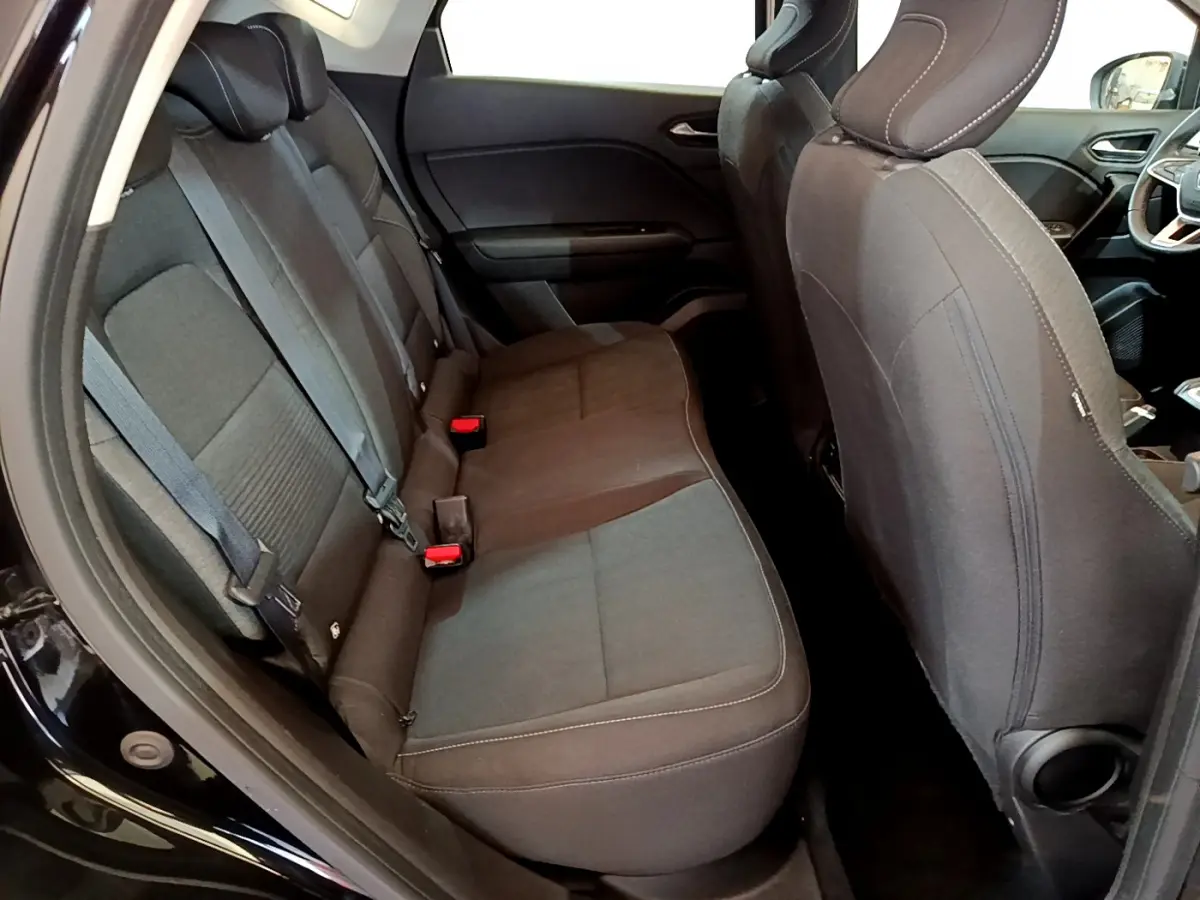 Vue intérieure côté gauche des sièges arrière noirs du Renault Captur Business TCe 90 de 2021 avec ceintures visibles.