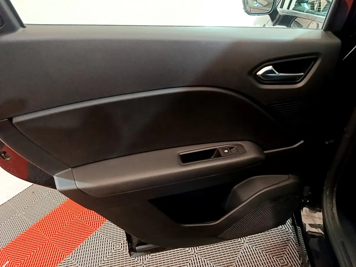Intérieur noir de la porte côté droit du Renault Captur Business TCe 90 2021 avec poignée et commandes de vitre.