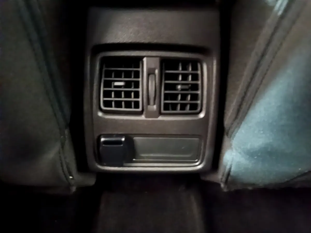 Vue rapprochée des bouches d'aération arrière noires entre les sièges avant du Renault Captur Business TCe 90 2021.