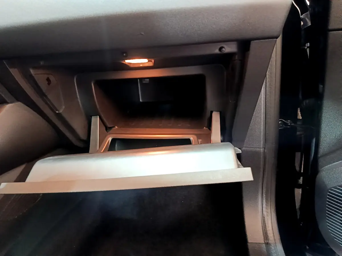 Intérieur du Renault Captur Business 2021, vue sur la boîte à gants ouverte côté passager, éclairage intérieur allumé.