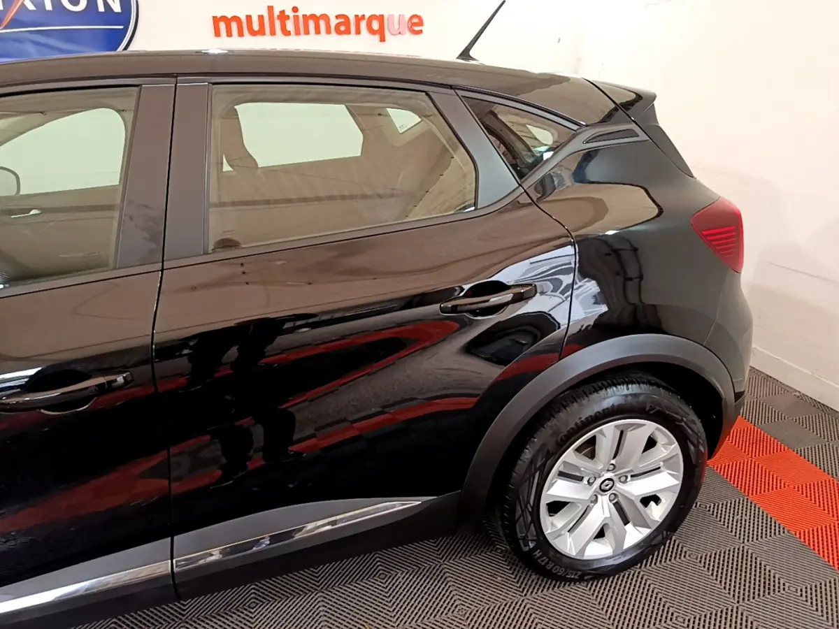 Profil côté droit du Renault Captur Business noir brillant, mettant en valeur la roue arrière et les lignes fluides du SUV.