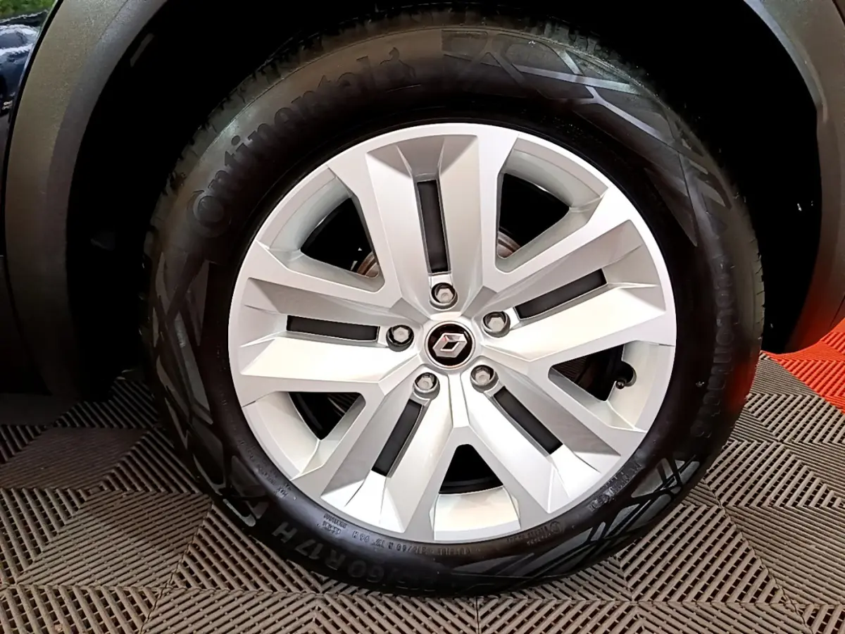 Gros plan sur la roue avant droite d'un Renault Captur noir 2021, avec passage de roue et partie de la carrosserie visible.