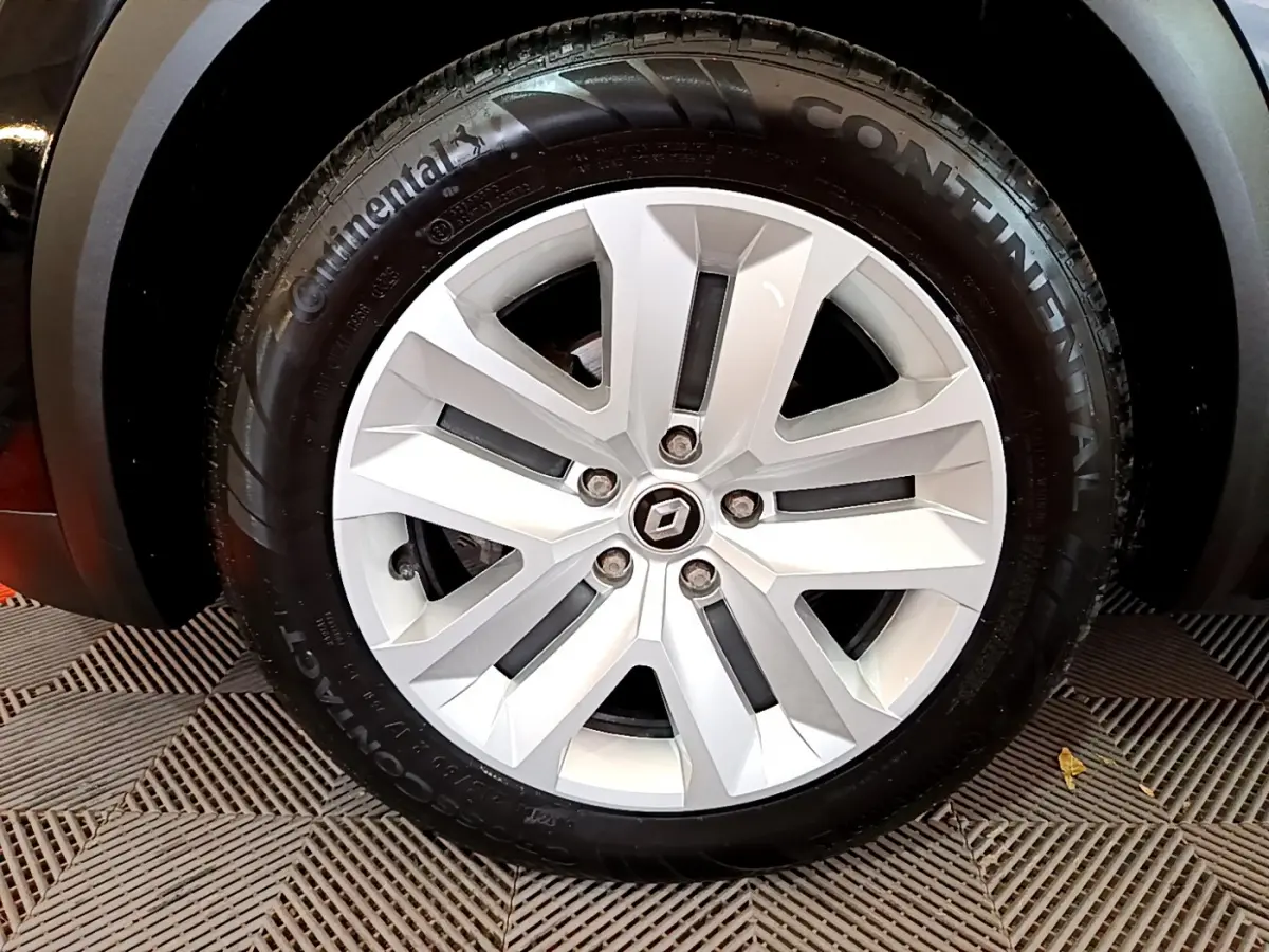 Gros plan sur la roue arrière droite d'un Renault Captur noir 2021 avec jante et pneu Continental visibles.