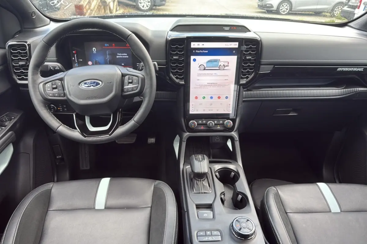 Intérieur du Ford Ranger 2025 noir agate, vue de face sur le tableau de bord avec écran tactile vertical et volant multifonction.