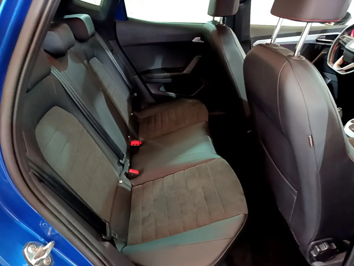 Vue intérieure côté gauche montrant les sièges arrière en tissu et cuir noir du SEAT Arona bleu 2022.