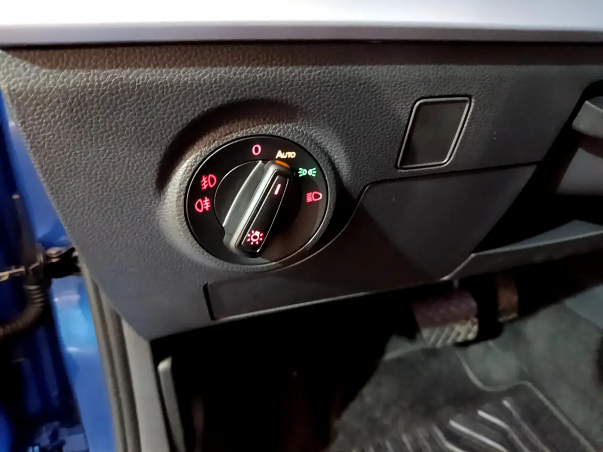 Gros plan sur le bouton de commande des phares dans l’habitacle d’un SEAT Arona bleu 2022.