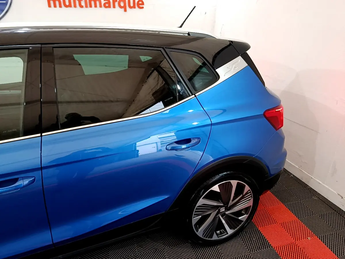 Vue côté droit arrière du SEAT Arona bleu 2022 avec jante alliage et toit noir contrasté.