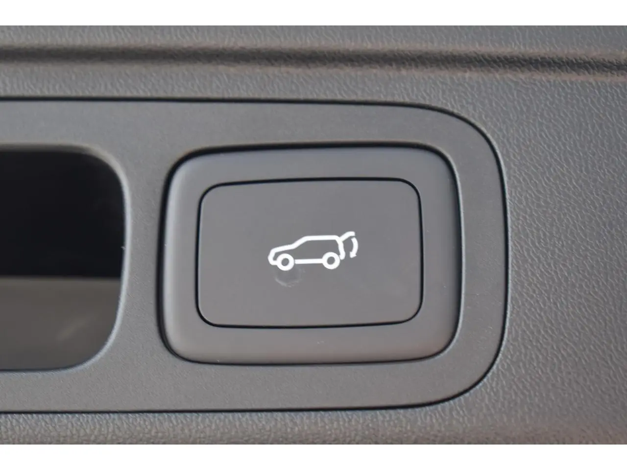 Bouton intérieur noir avec symbole blanc d'ouverture de hayon sur MG Motor EHS 1.5 Hybrid+ 2026.