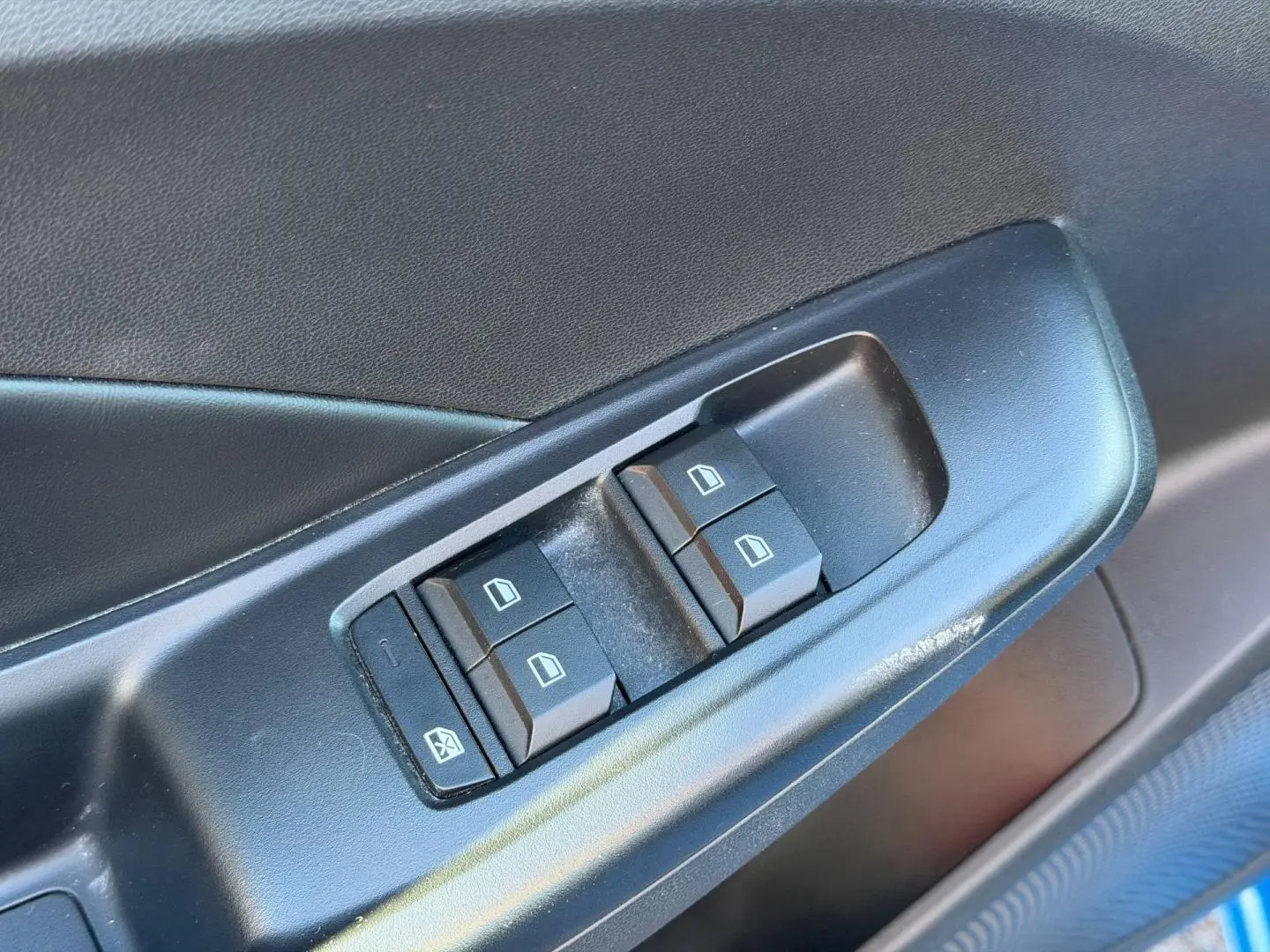 Gros plan sur les commandes des vitres électriques côté gauche d’une MG3 1.5 Hybrid+ 195ch Comfort en Como Blue métallisé.