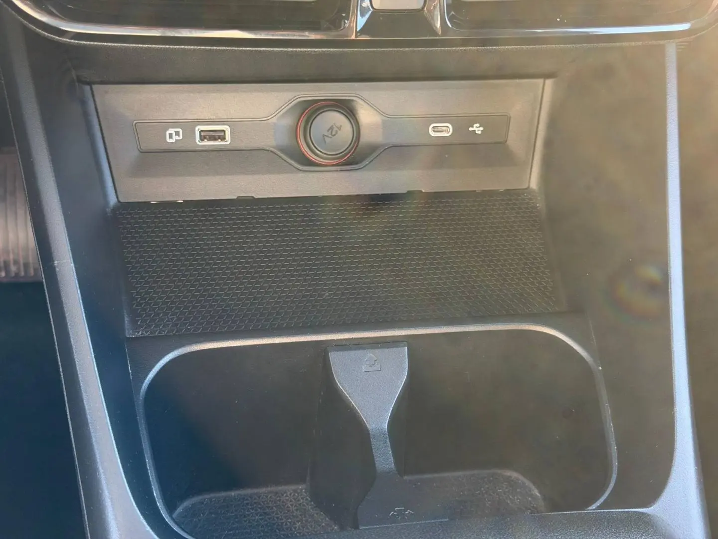 Gros plan sur la console centrale noire du MG3 1.5 Hybrid+ 2025 avec prise 12V et ports USB visibles.