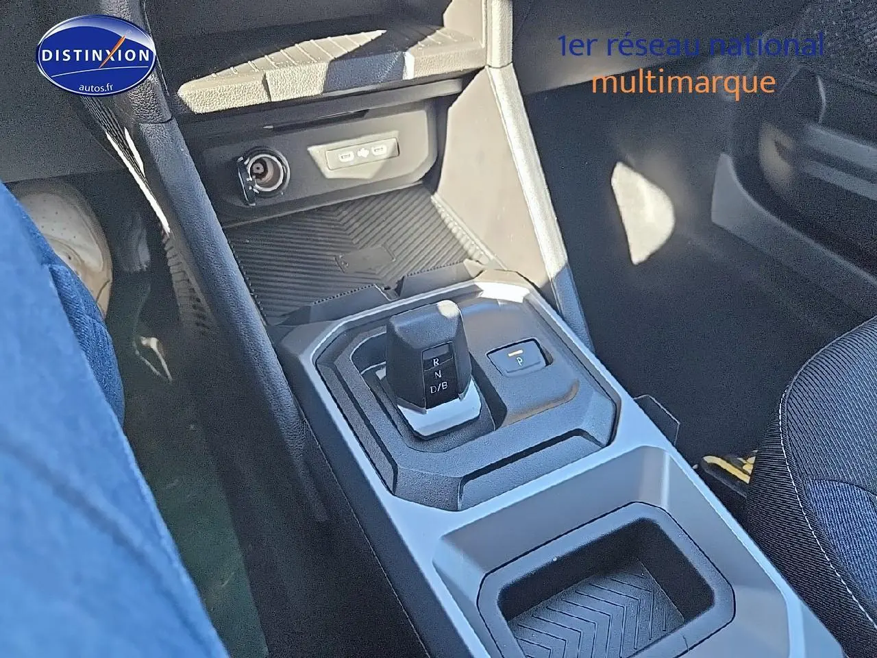 Gros plan sur la console centrale du Dacia Duster 2025 brun terracotta, mettant en valeur le levier de vitesses et les rangements.