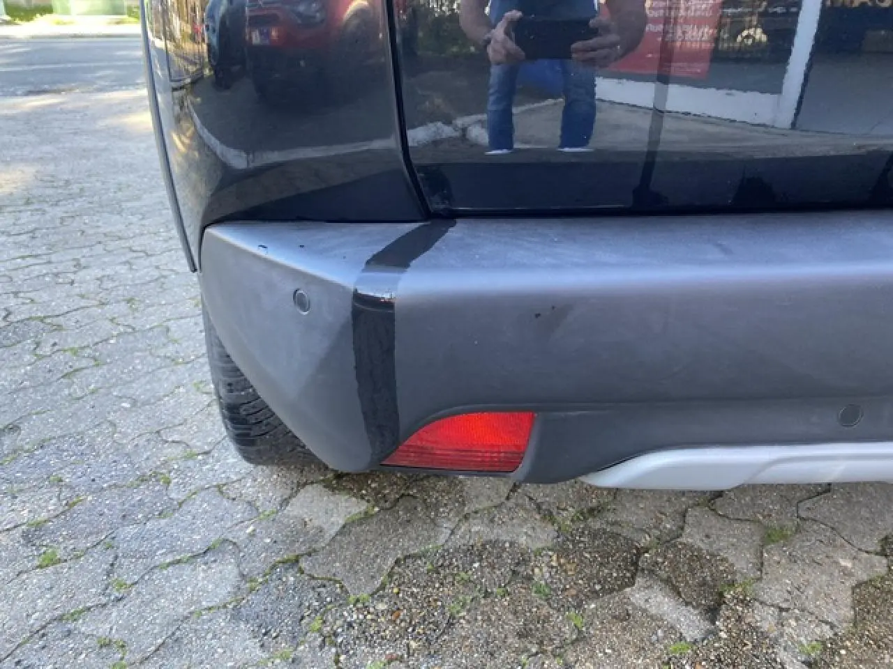 Gros plan sur le coin arrière gauche noir métallisé du Peugeot 2008 2019 avec feu rouge et pare-chocs gris.