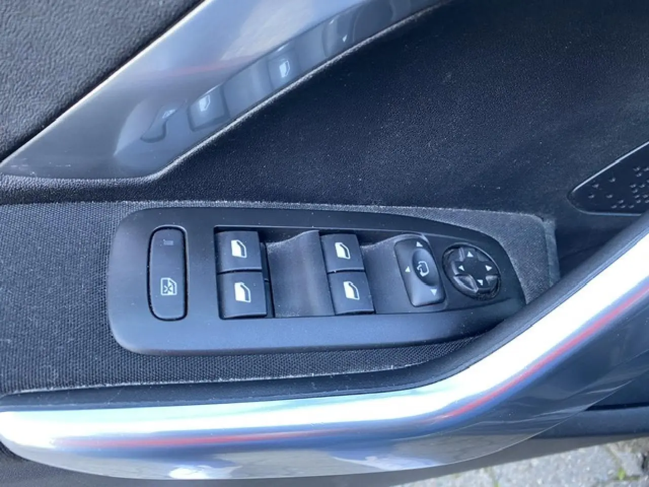 Vue rapprochée des commandes des vitres et rétroviseurs sur la porte côté conducteur du Peugeot 2008 noir 2019.