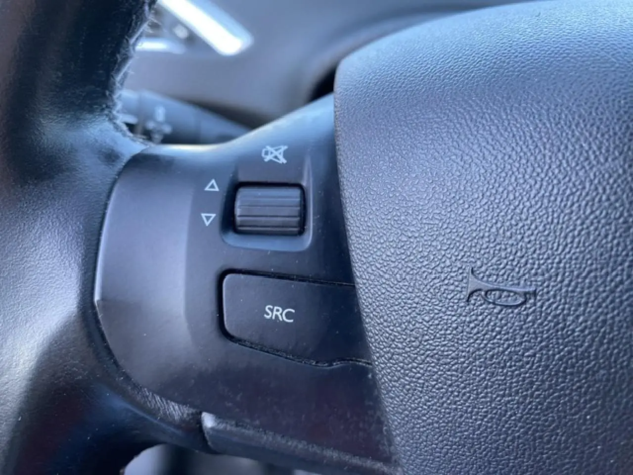 Gros plan sur les commandes audio au volant noir du Peugeot 2008 2019 version Allure diesel.