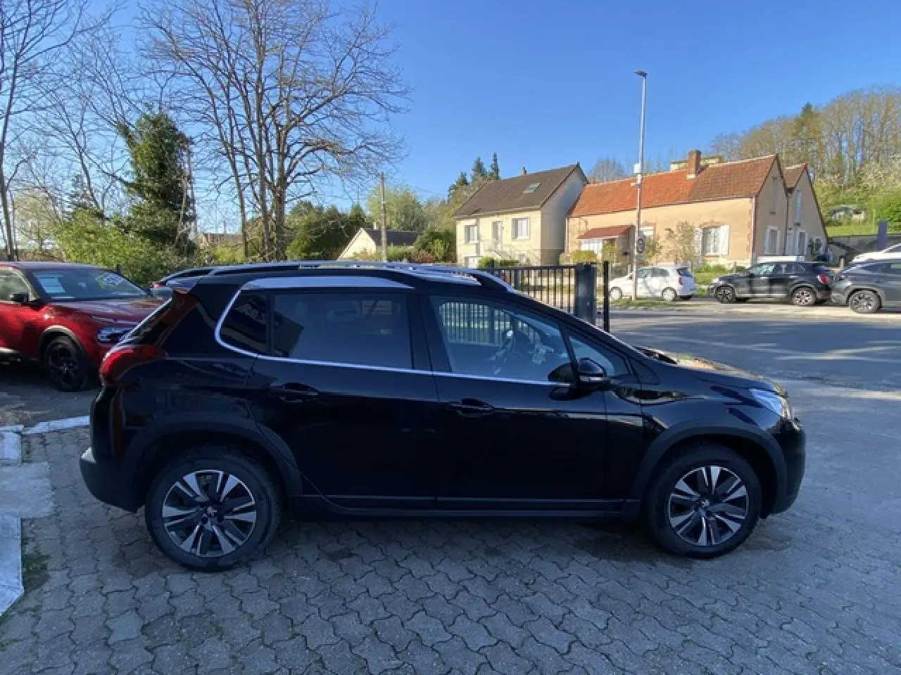 Profil côté gauche d'un Peugeot 2008 noir métallisé de 2019 avec jantes aluminium 16 pouces diamantées.
