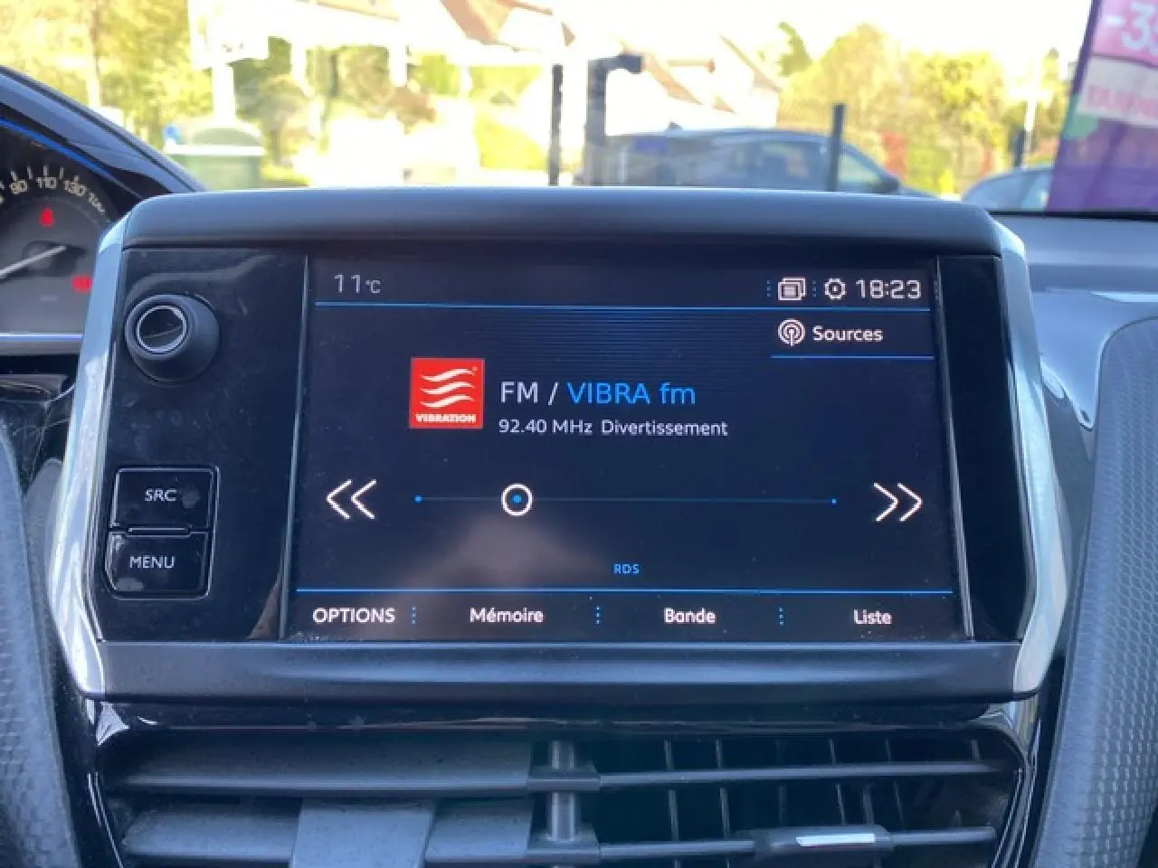 Écran tactile central du tableau de bord du Peugeot 2008 2019 affichant la radio FM VIBRA fm à 18h23.