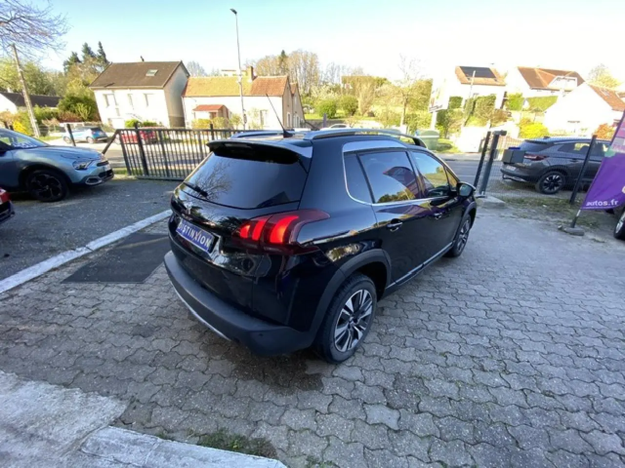 Peugeot 2008 noire vue en 3/4 arrière droit, avec jantes aluminium diamantées et vitres teintées.