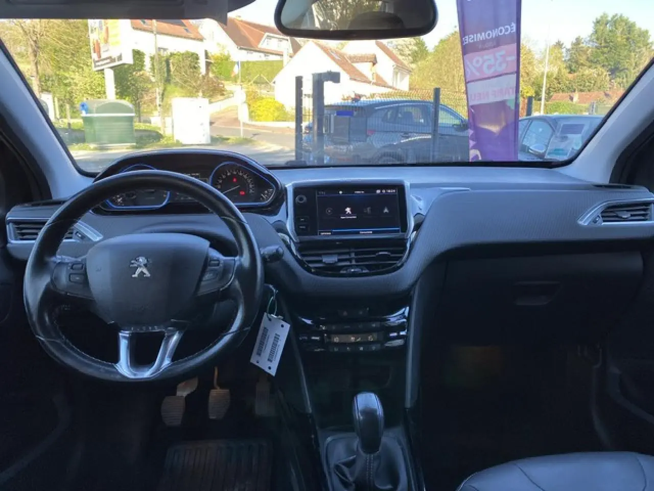 Intérieur noir du Peugeot 2008 2019, vue frontale sur le tableau de bord avec écran tactile et volant multifonction.
