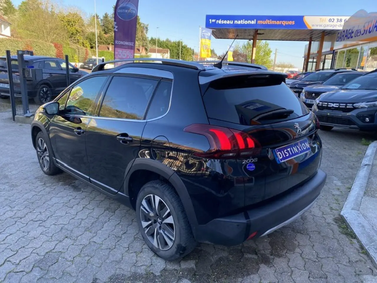 Peugeot 2008 noir métallisé vue 3/4 arrière côté droit, avec jantes aluminium diamantées et vitres teintées.