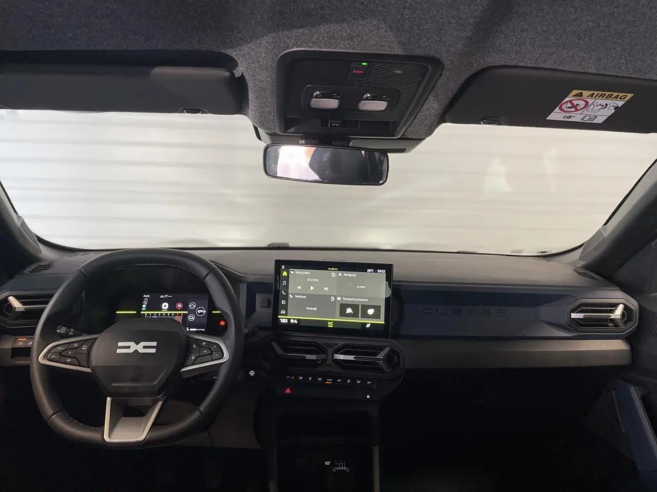 Vue frontale de l'intérieur du Dacia Duster beige 2025, avec tableau de bord digital et écran tactile central.