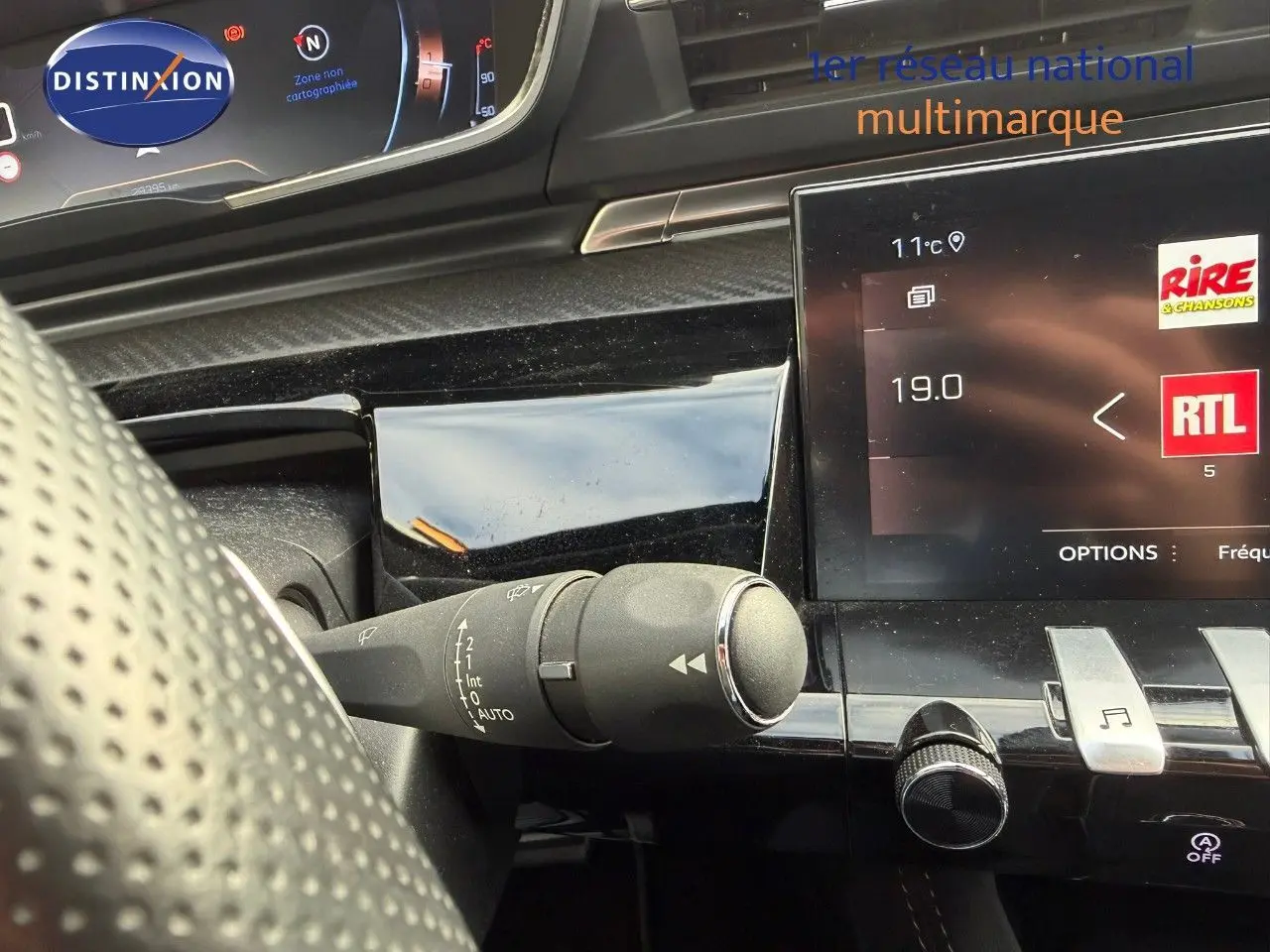 Gros plan sur le commodo d'essuie-glace côté gauche du tableau de bord d'une Peugeot 508 gris platinium 2023.