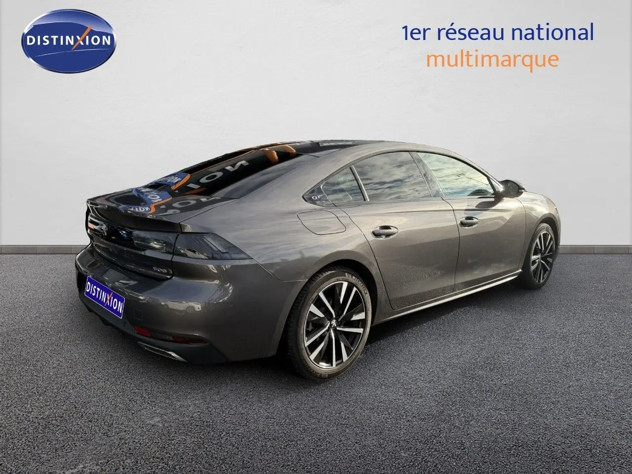 Peugeot 508 gris platinium vue 3/4 arrière droit, élégante berline avec jantes alliage et feux LED distinctifs.