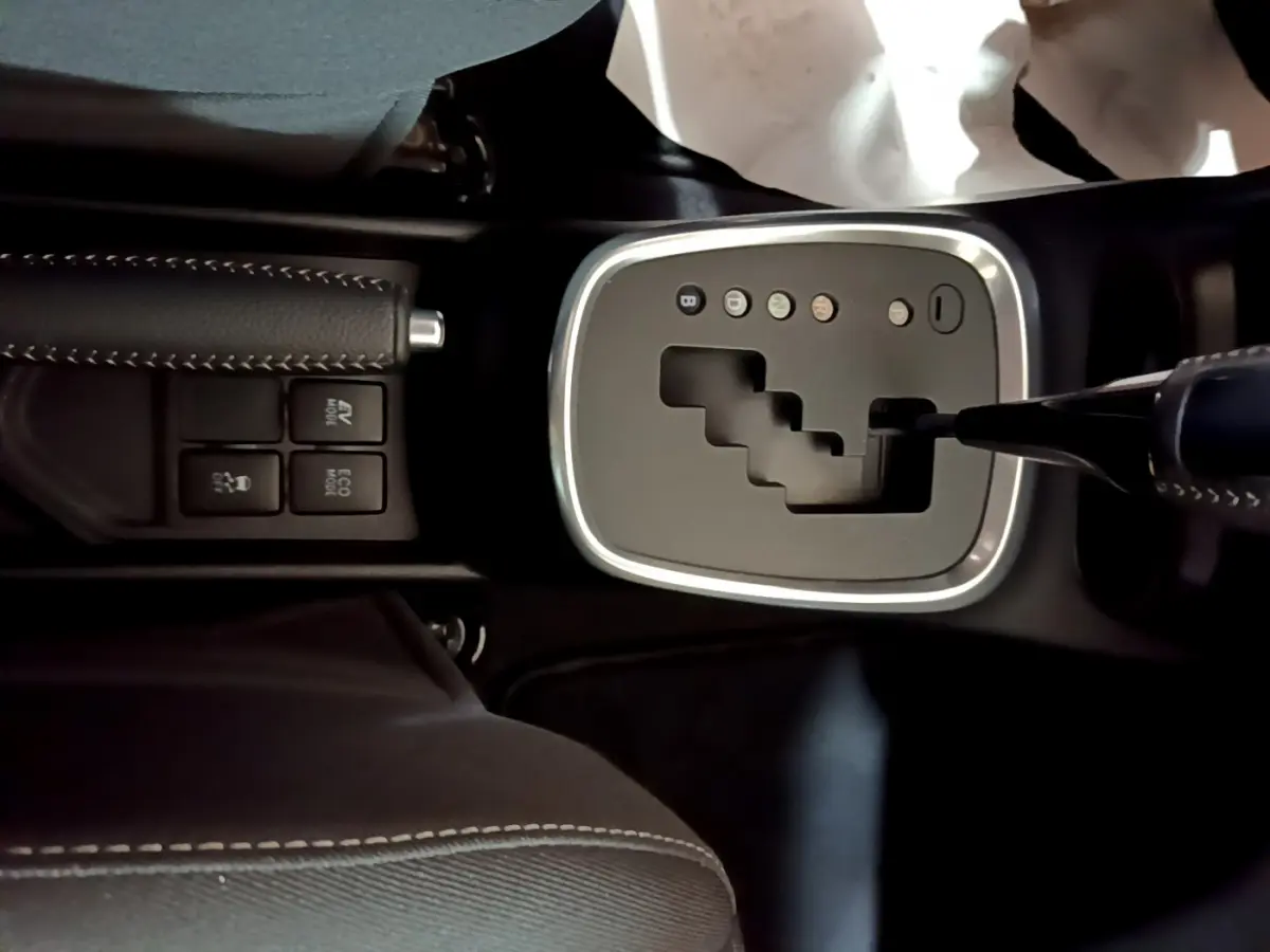 Vue rapprochée de la console centrale de la Toyota Yaris 1.5 Hybride 2020, montrant la boîte automatique et le frein à main cuir noir.