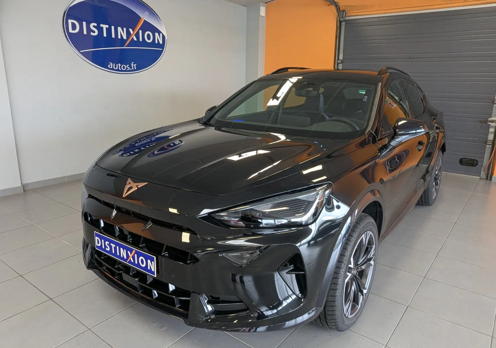 Silhouette stylisée d'une voiture en bleu et orange avec le texte "en arrivage" sur fond blanc.