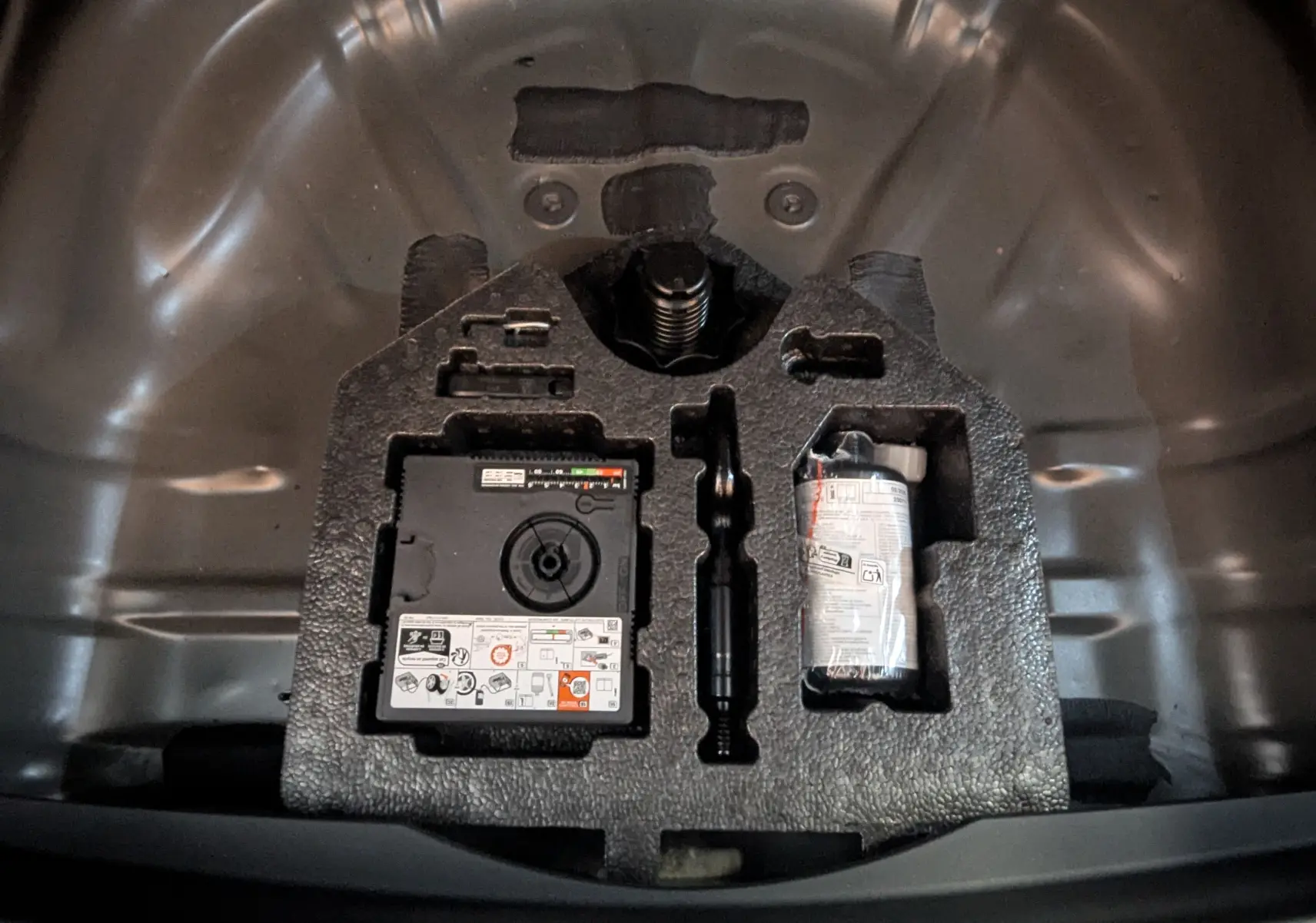 Vue plongeante sur le coffre d'une CUPRA Formentor 2.0 TDI 150 DSG7 noir, montrant le kit de réparation pneu intégré.