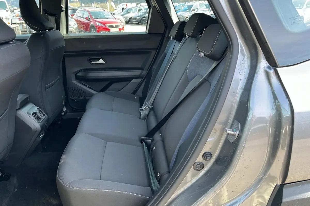 Vue intérieure côté arrière droit du DACIA BIGSTER gris schiste, montrant la banquette arrière en tissu avec ceinture de sécurité.