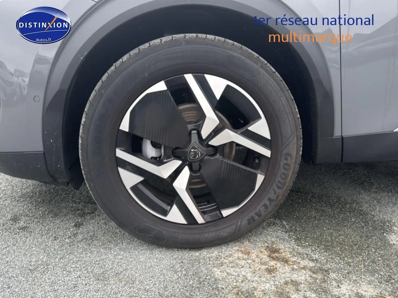 Gros plan sur la roue avant droite du Peugeot 2008 gris sélénite avec jante alu au design moderne.
