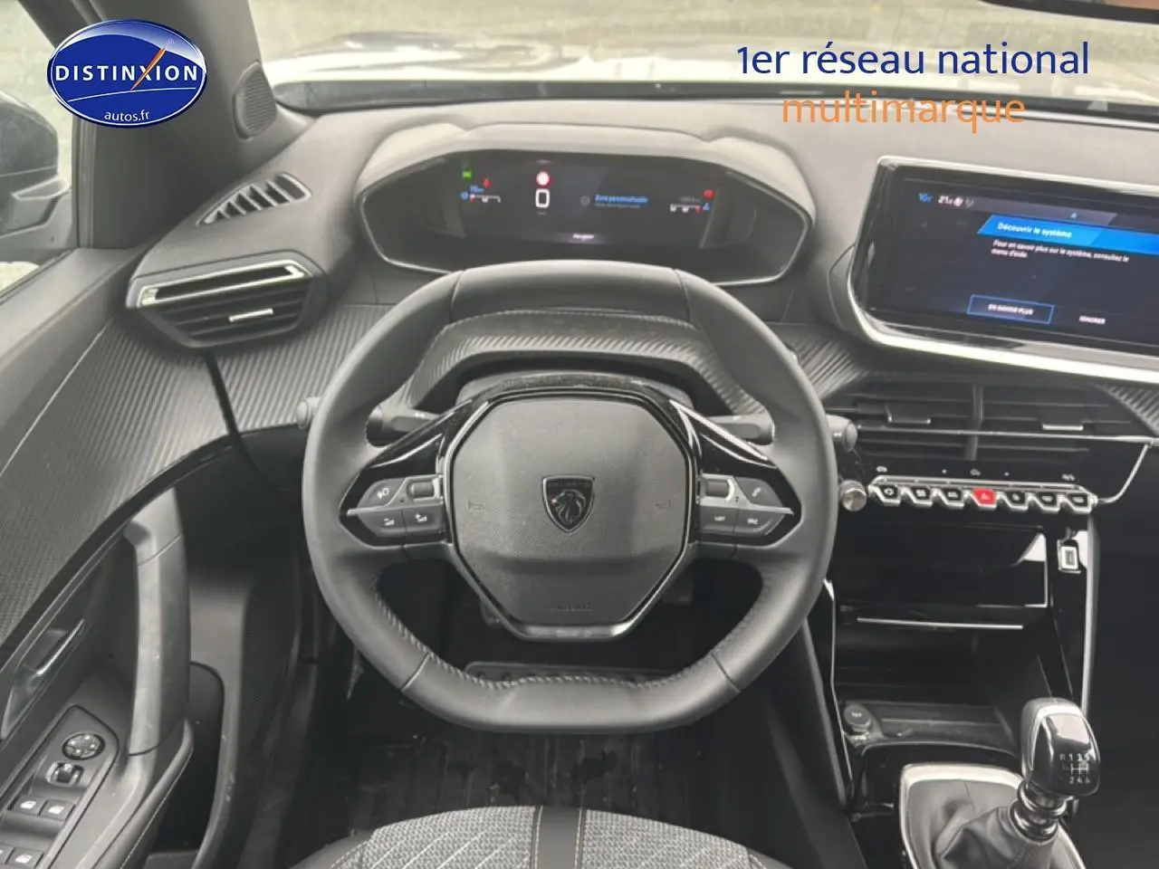 Vue intérieure centrée sur le volant Peugeot 2008 1.2 100 allure, tableau de bord et écran tactile visibles.