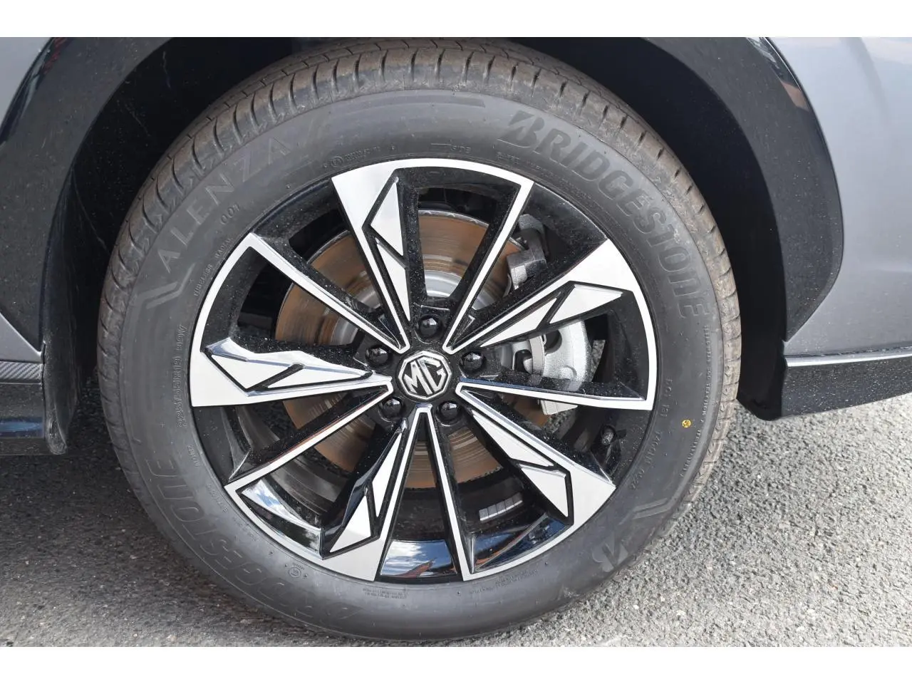 Gros plan sur la jante alliage 19 pouces bicolore du MG MOTOR EHS gris, avec logo MG au centre.
