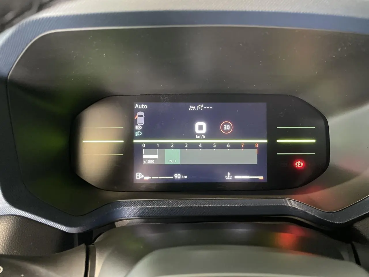 Tableau de bord digital du Dacia Duster 2025 affichant la vitesse à 0 km/h et indicateurs de sécurité allumés.