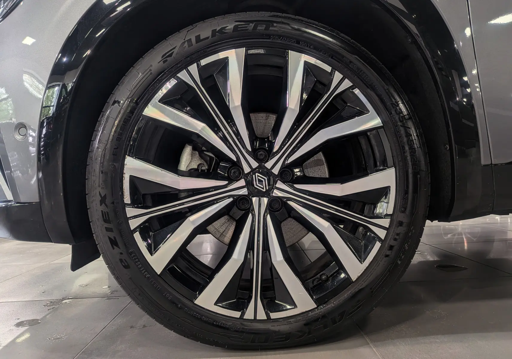 Gros plan sur la jante alliage bicolore du Renault Austral E-TECH gris schiste, soulignant le design moderne et le logo central.