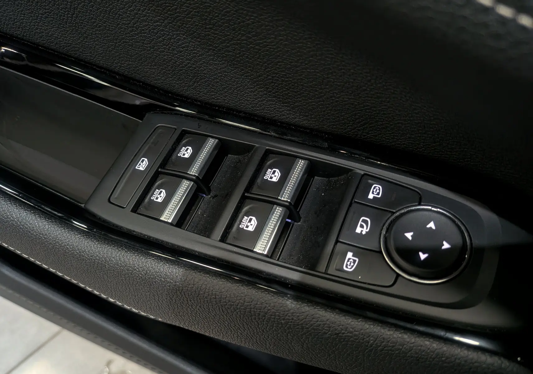 Gros plan sur les commandes des vitres électriques et rétroviseurs côté conducteur du Renault Austral gris Schiste 2024.