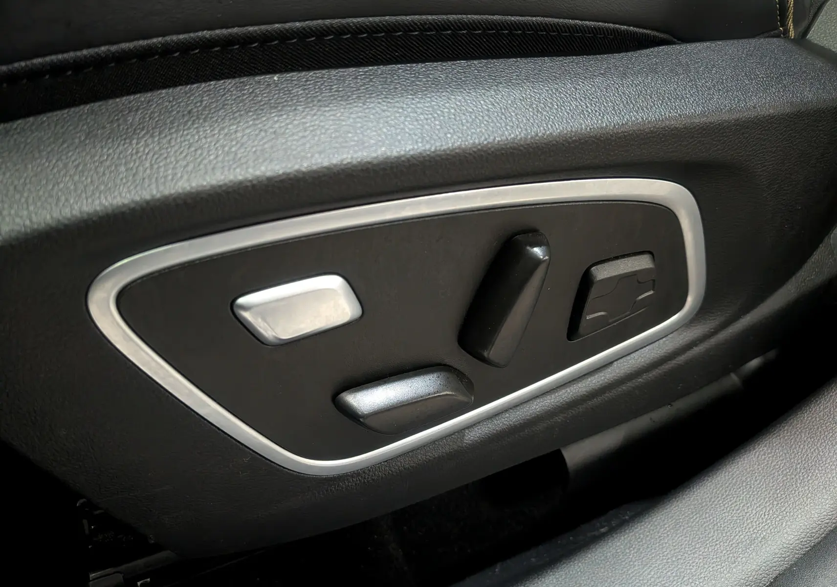 Commandes de réglage électrique des sièges en cuir noir dans une Renault Austral E-TECH Gris Schiste 2024.