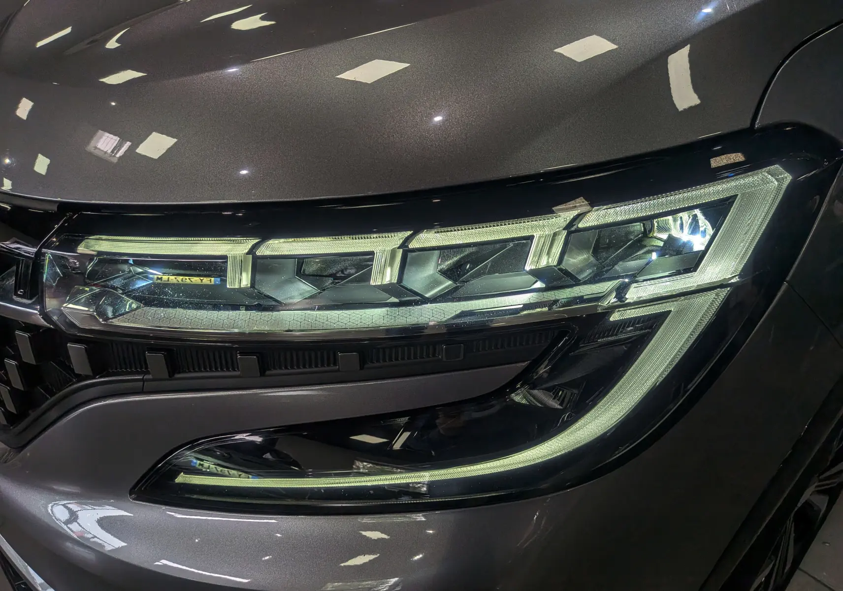 Gros plan sur le phare avant droit du Renault Austral gris schiste 2024, mettant en valeur son design LED distinctif.